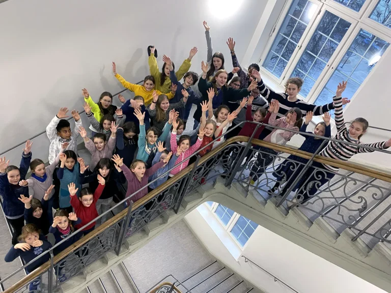 Kinderchor Nachtigallen winkt im Treppenhaus